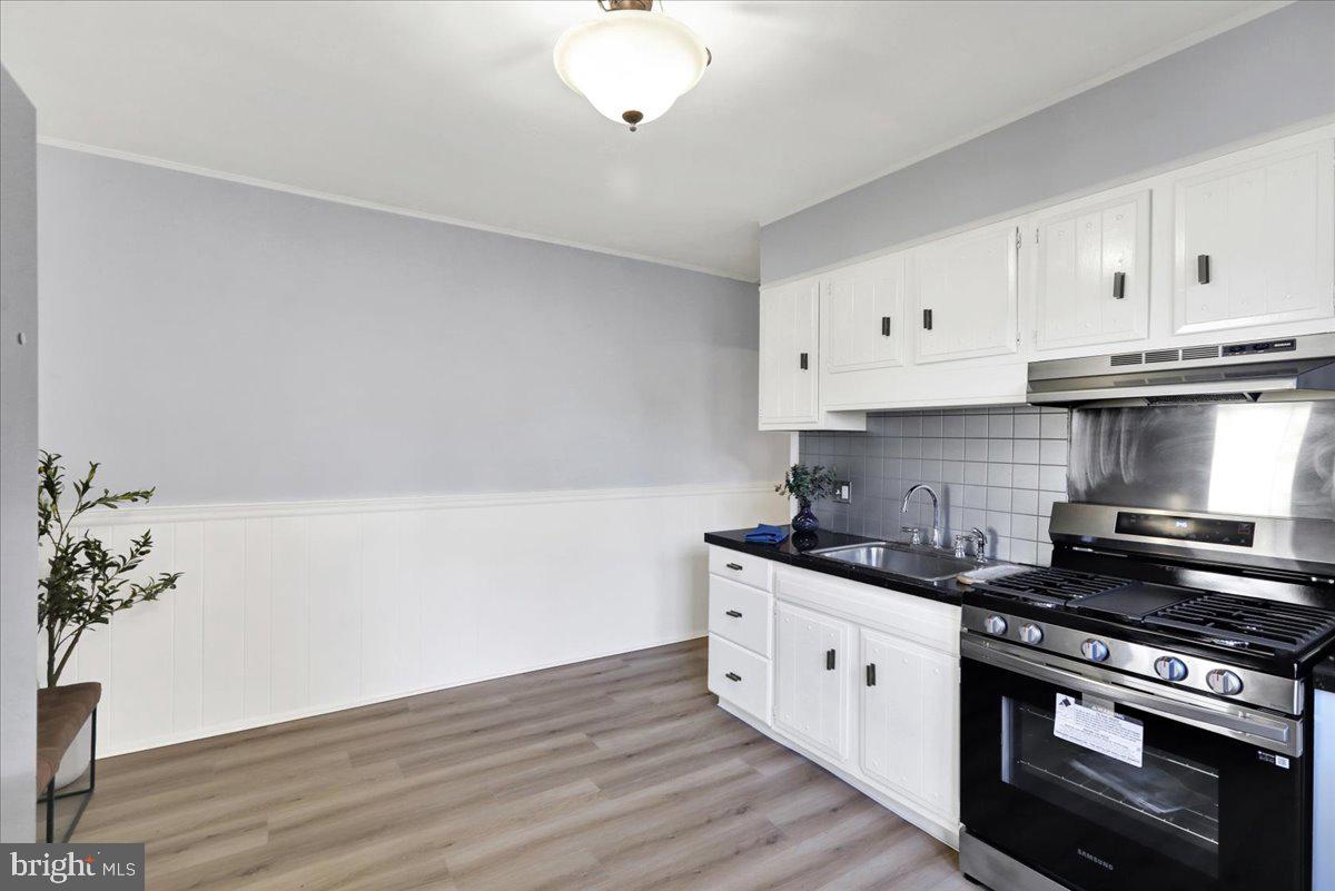 2133 Fairview Street Reading, PA 19609 - Photo 11 of 34 a kitchen with granite countertop a stove and a white cabinets