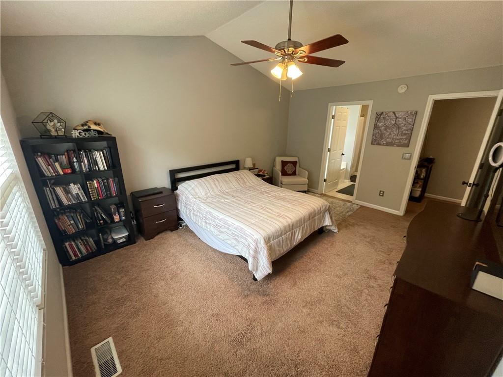 1720 Fort Daniels Trail Dacula, GA 30019 - Photo 14 of 32 a spacious bedroom with a bed and a chandelier