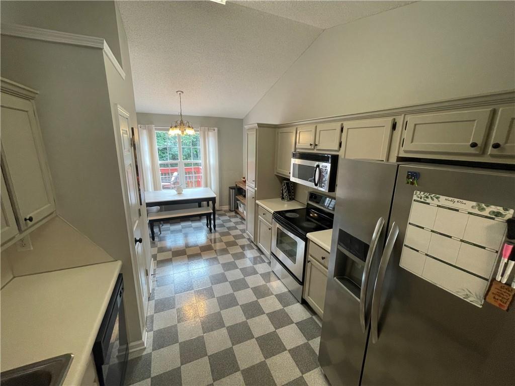 1720 Fort Daniels Trail Dacula, GA 30019 - Photo 19 of 32 a kitchen with granite countertop a stove a sink and a refrigerator