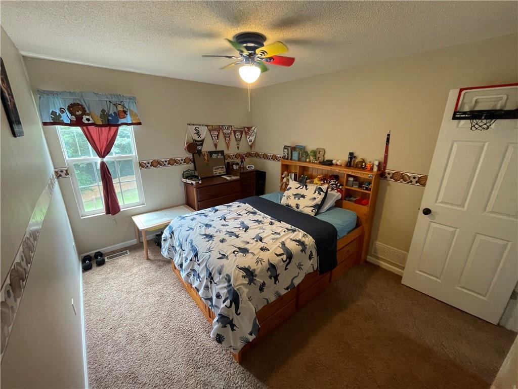 1720 Fort Daniels Trail Dacula, GA 30019 - Photo 27 of 32 a bedroom with bed and a chandelier