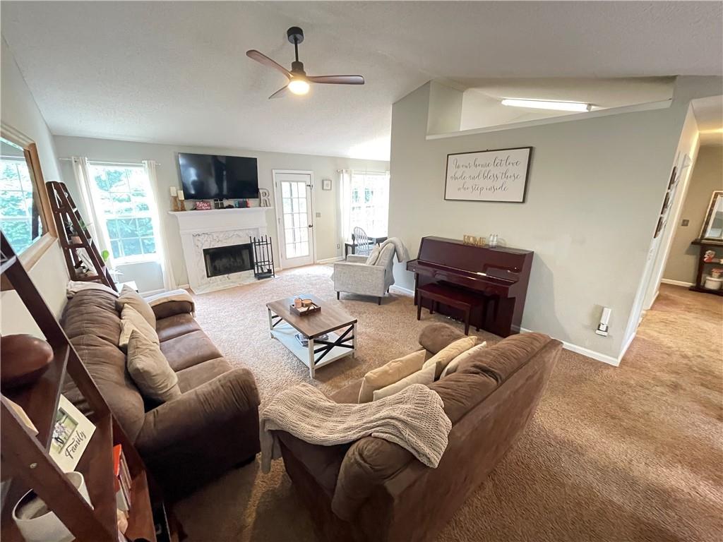 1720 Fort Daniels Trail Dacula, GA 30019 - Photo 6 of 32 a living room with furniture a fireplace and a flat screen tv