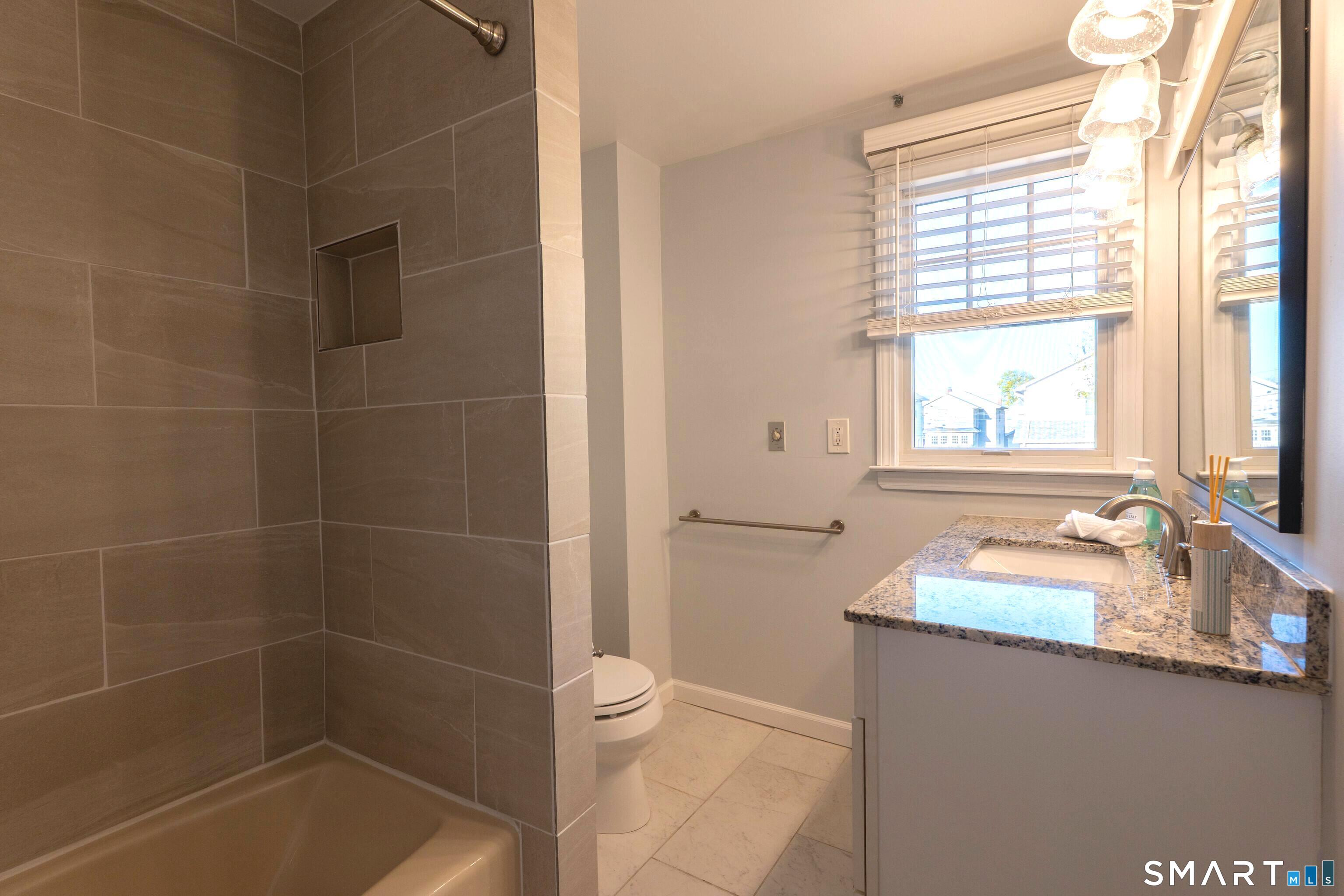 19 Elaine Road Milford, CT 06460 - Photo 13 of 24 a bathroom with a tub sink and window