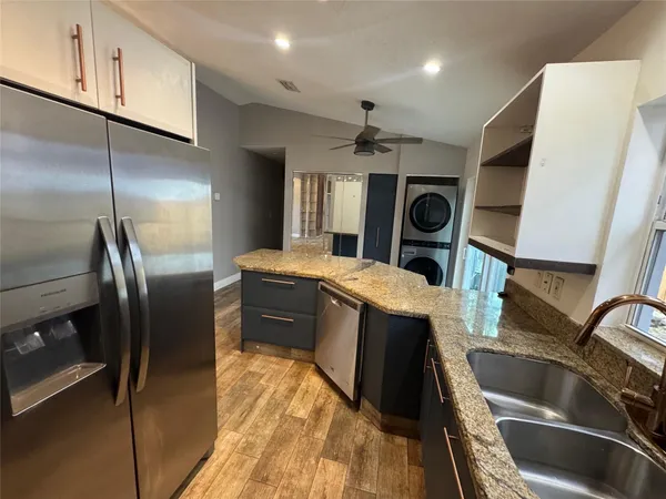 a bathroom with a granite countertop sink and a refrigerator