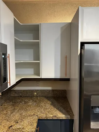 a kitchen with kitchen island granite countertop a sink a stove and cabinets