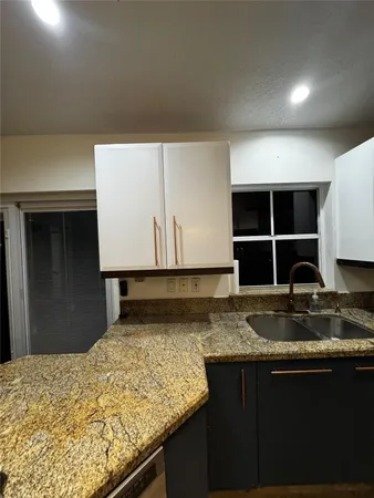 a kitchen with a sink a counter top space cabinets and stainless steel appliances