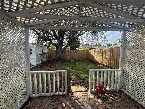 a view of wooden house with a small backyard