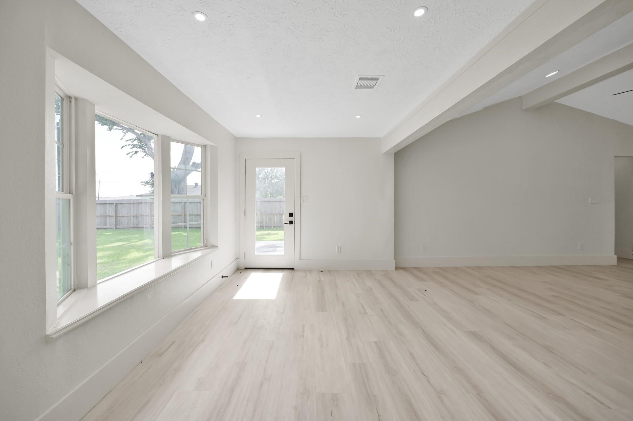 6026 Willowbend Boulevard Houston, TX 77096 - Photo 21 of 46 a view of an empty room with a window and wooden floor