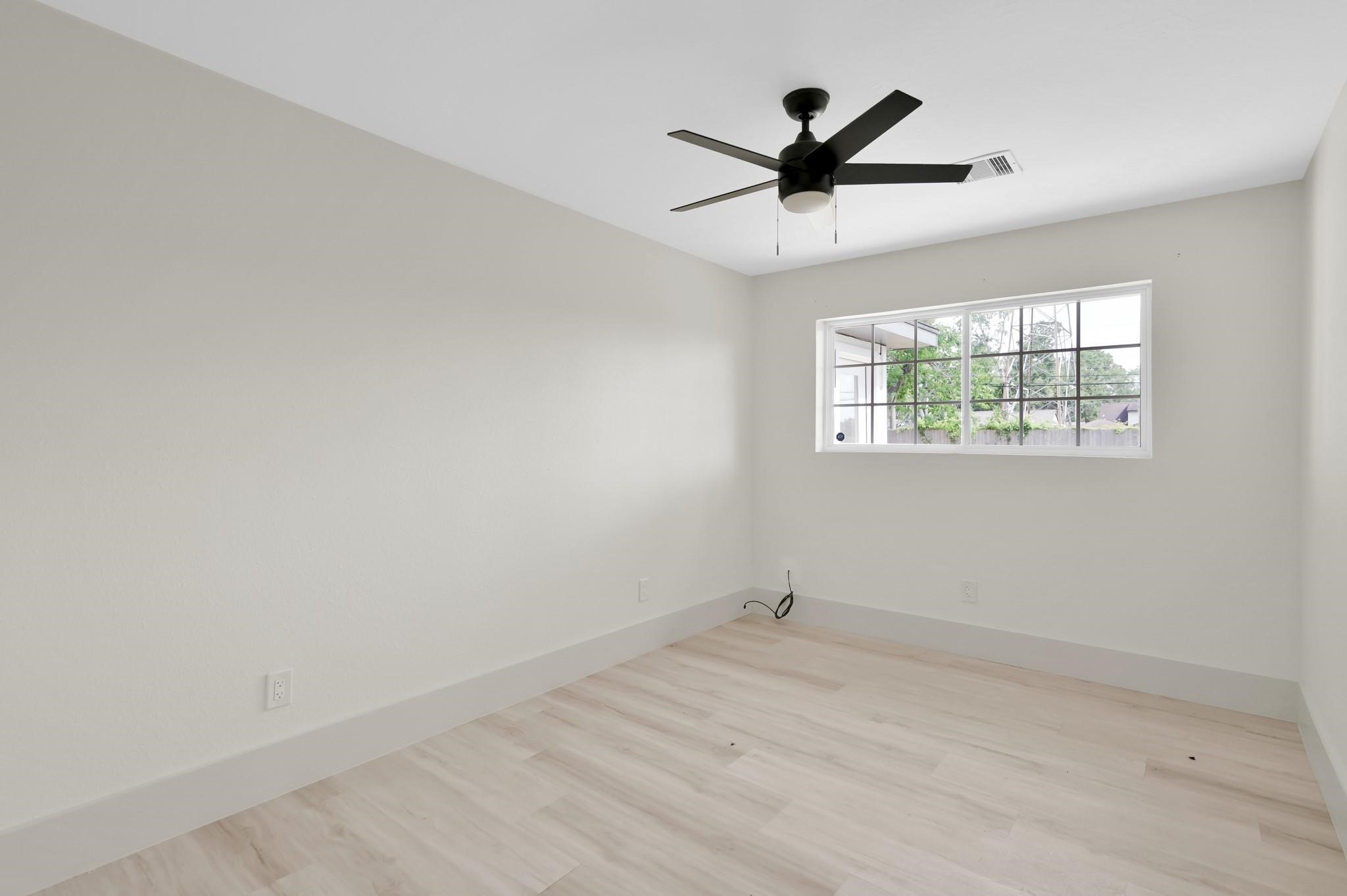 6026 Willowbend Boulevard Houston, TX 77096 - Photo 36 of 46 an empty room with a ceiling fan and window