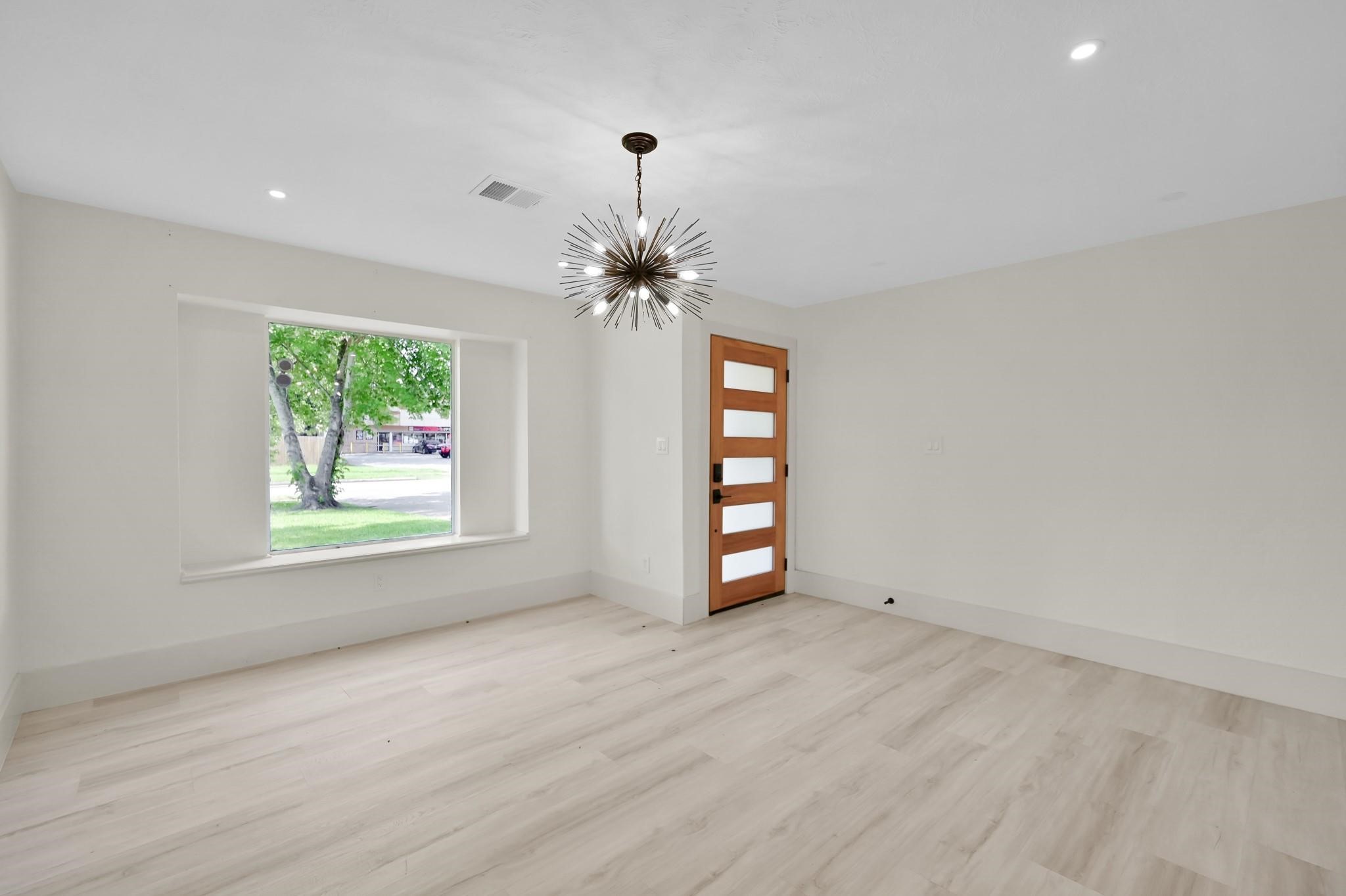 6026 Willowbend Boulevard Houston, TX 77096 - Photo 6 of 46 wooden floor in an empty room with a window