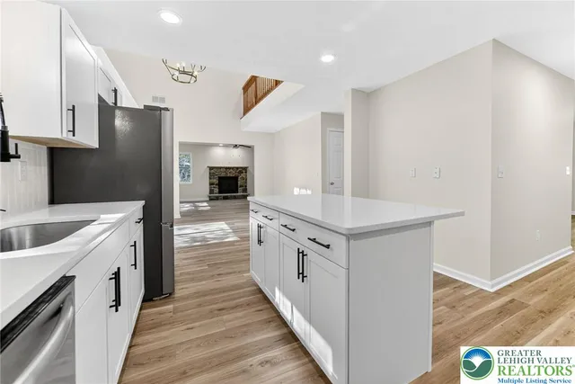 a kitchen with stainless steel appliances granite countertop a white house with a sink and dishwasher