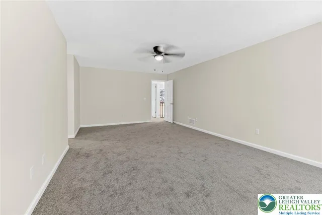an empty room with a window and a ceiling fan