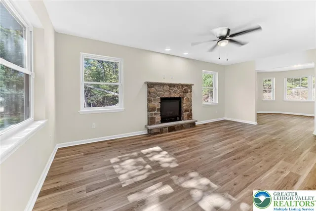a view of an empty room with a window and fireplace