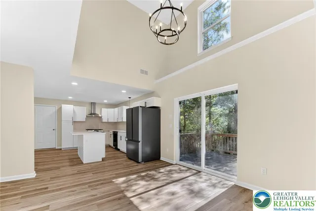 a view of a kitchen with refrigerator and windows