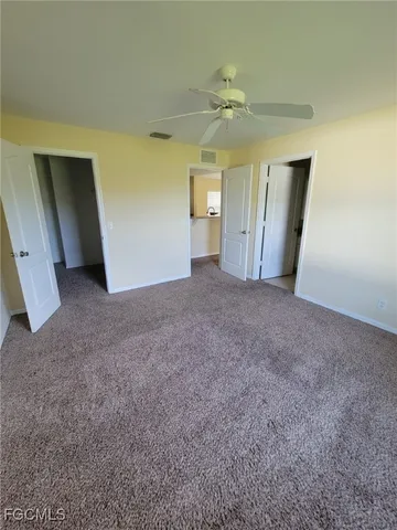 a view of a big room with windows and chandelier fan