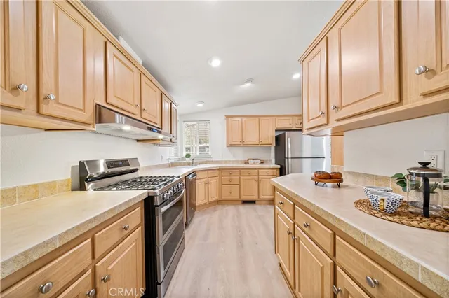 a kitchen with stainless steel appliances granite countertop a stove a sink and a white cabinets