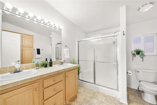 a bathroom with a double vanity sink toilet and shower