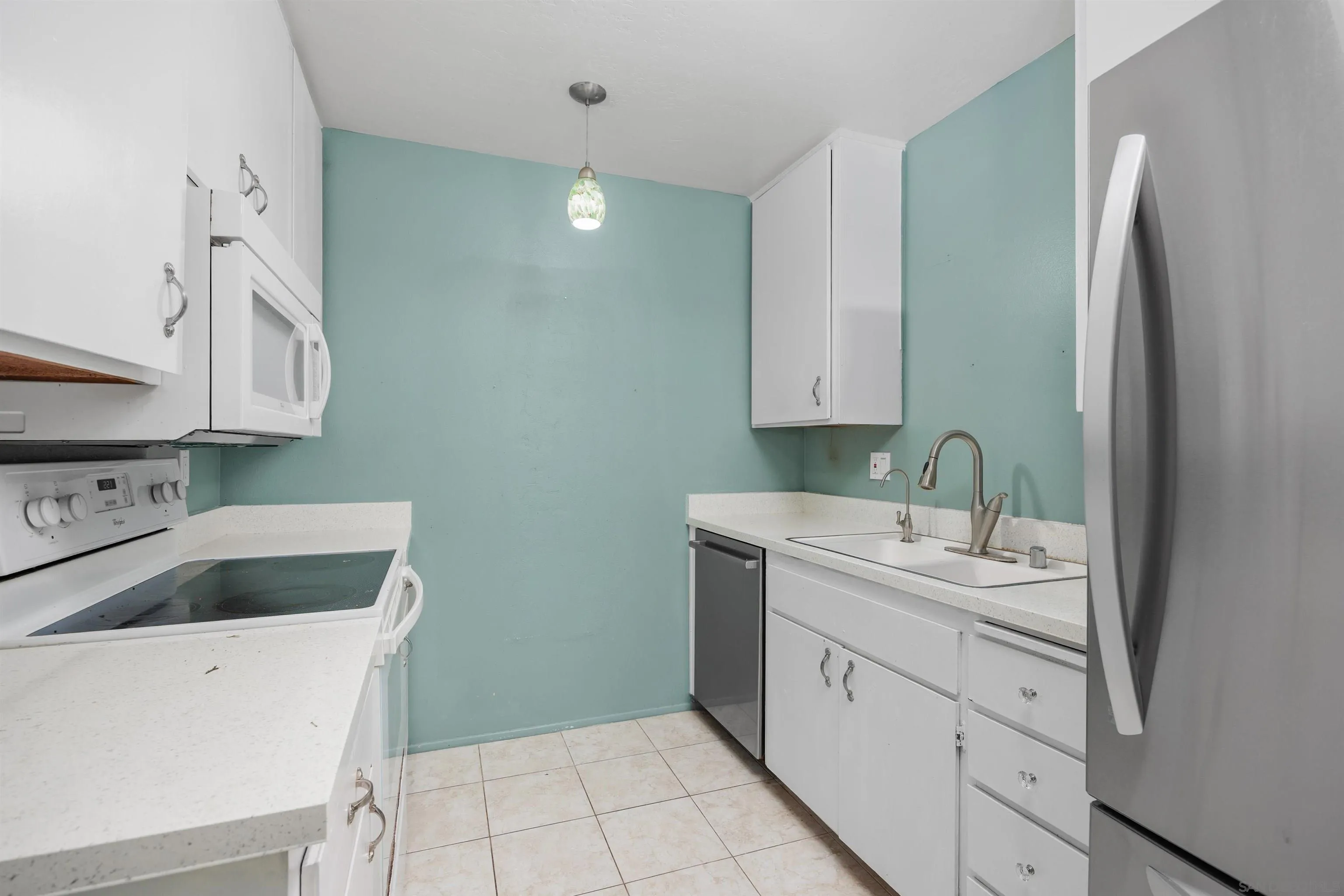 407 Requeza Street, Unit E9 Encinitas, CA 92024 - Photo 7 of 19 a view of cabinets a sink and dishwasher in a kitchen