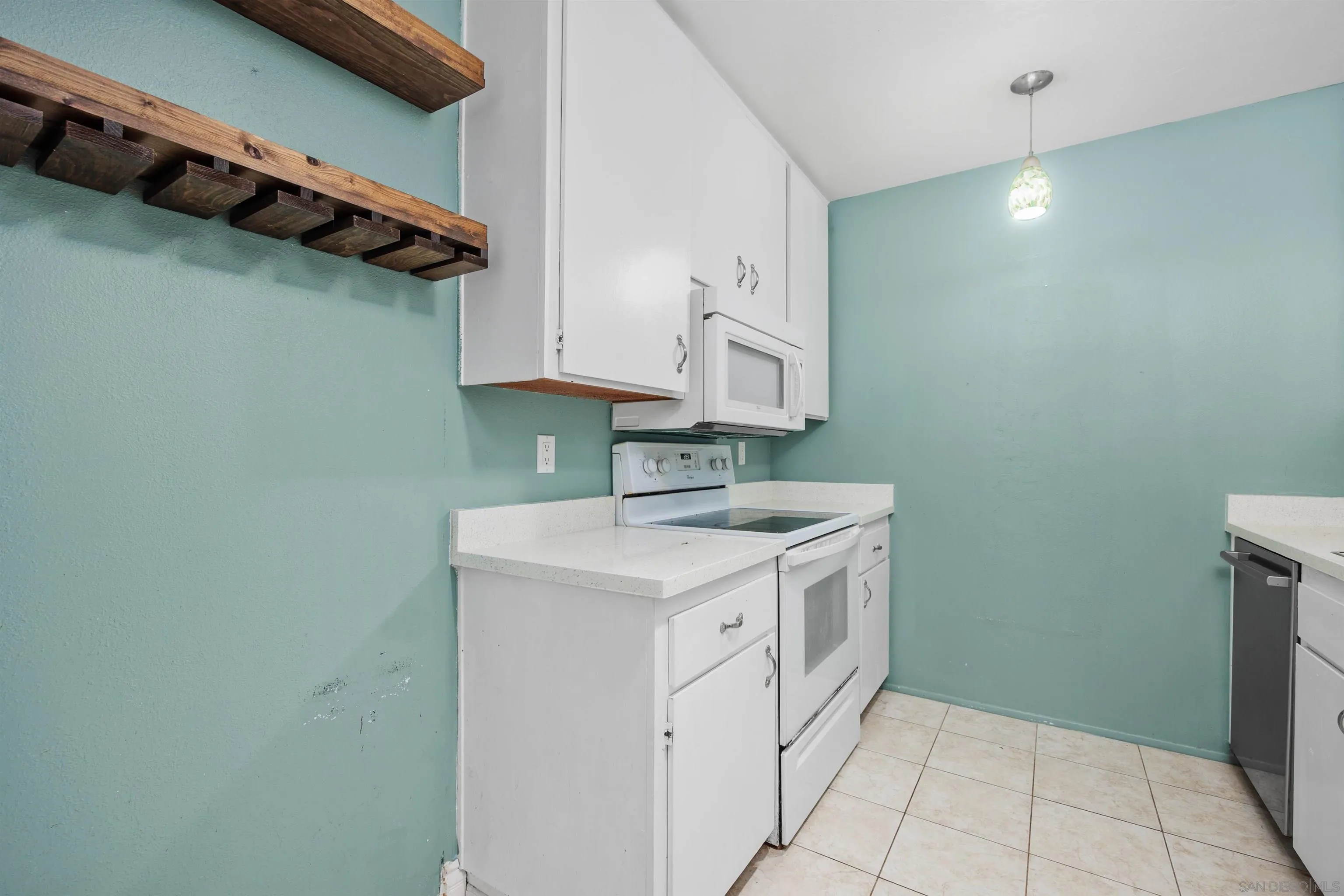 407 Requeza Street, Unit E9 Encinitas, CA 92024 - Photo 9 of 19 a kitchen with white cabinets and white appliances