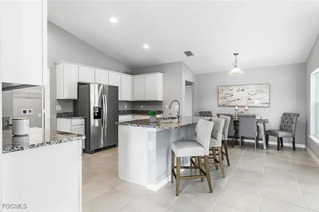 a kitchen with refrigerator and chairs