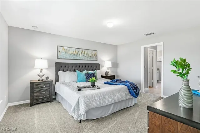 a bedroom with a bed a mirror and potted plant