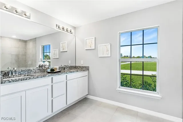 a bathroom with a double vanity sink and a window