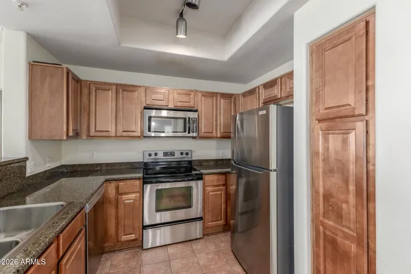 a kitchen with stainless steel appliances granite countertop a refrigerator stove and sink
