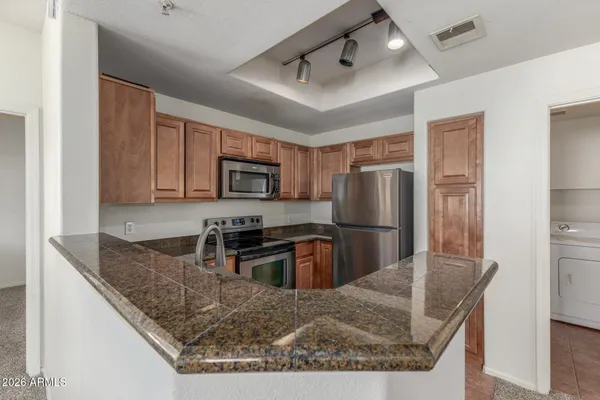 a kitchen with stainless steel appliances granite countertop a refrigerator a stove a sink a stove and island