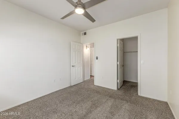 an empty room with a ceiling fan and a window