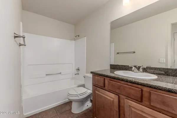 a bathroom with a granite countertop toilet sink and mirror