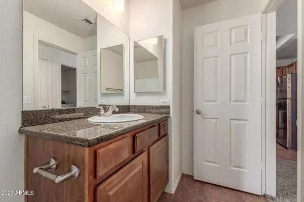 a bathroom with a granite countertop sink and a mirror