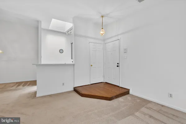 en empty room with an entryway and kitchen view