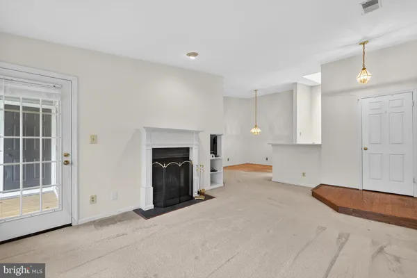 a view of a livingroom with a fireplace and window