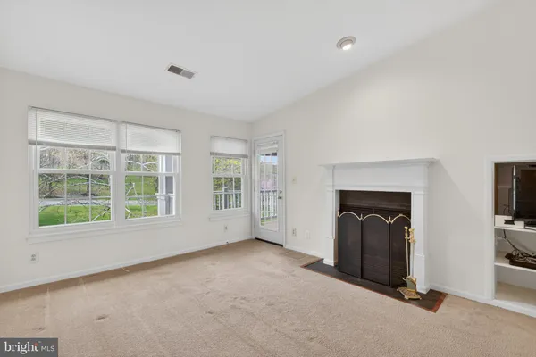 a view of an empty room with a fireplace and a window