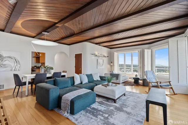 a dining room with furniture and a potted plant