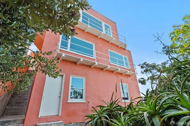 a yellow building with trees in front of it