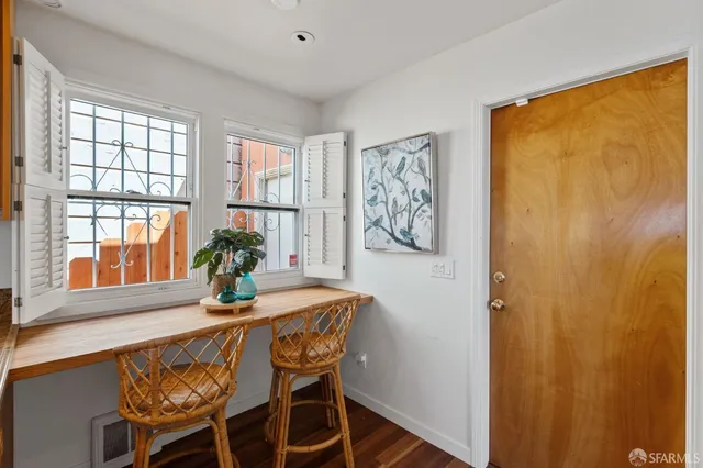 a living room with furniture kitchen view and a window