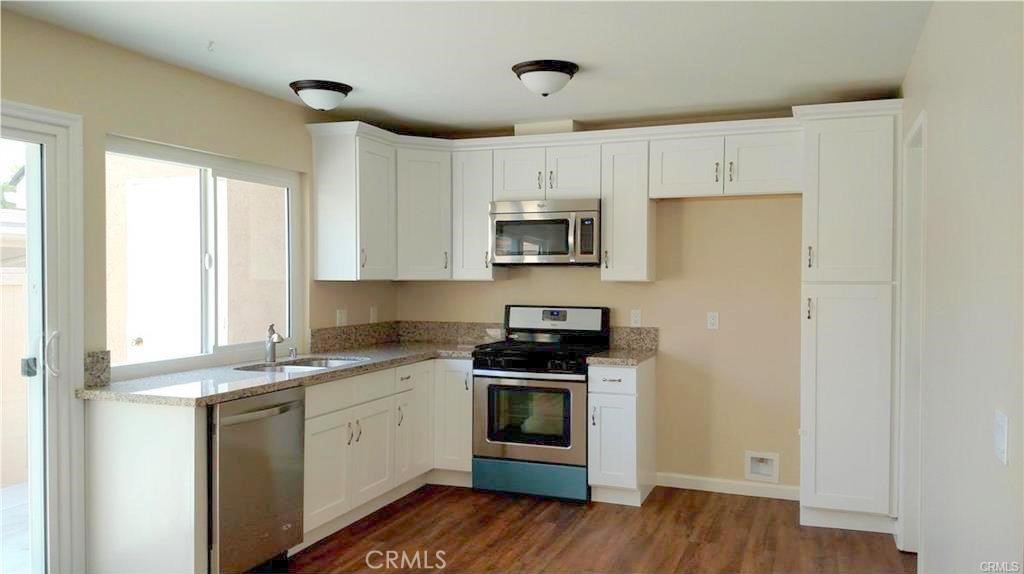 8 Sage Irvine, CA 92604 - Photo 5 of 32 a kitchen with a stove a sink and a microwave