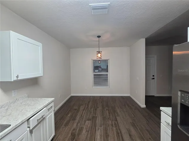 a view of a kitchen with wooden floor and a window