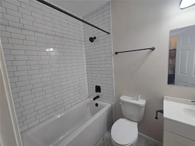 a white toilet sitting next to a bath tub