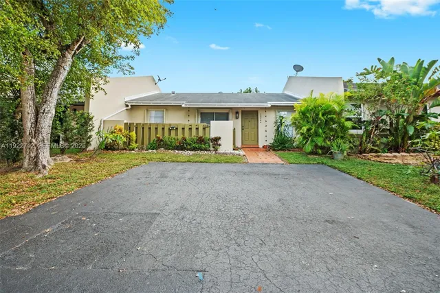 a front view of a house with a yard and potted plants