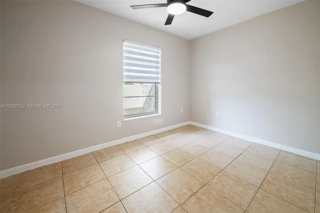 an empty room with windows and ceiling fan