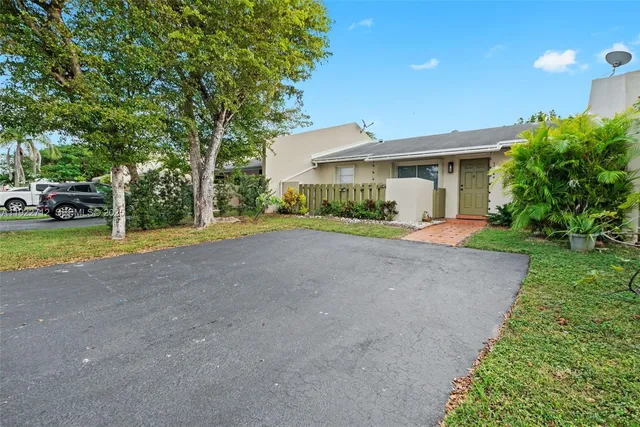 a view of a house with a big yard and large trees