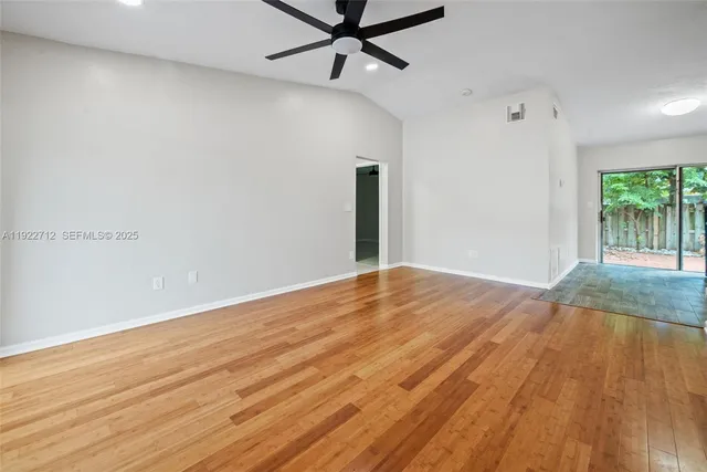 a view of a livingroom with wooden floor and a ceiling fan