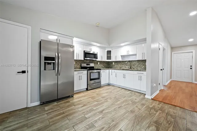 a large kitchen with a refrigerator and a sink