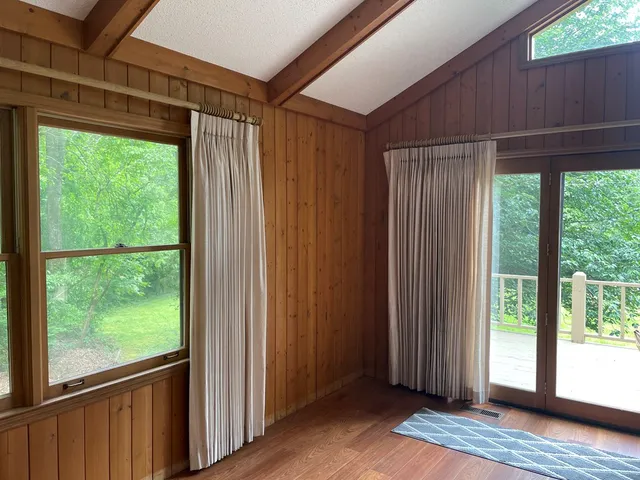 a view of empty room with wooden floor and doors