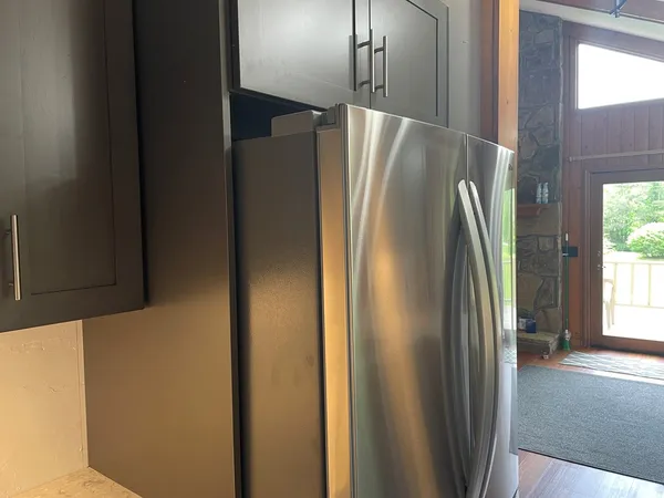 a metallic refrigerator freezer sitting inside of a kitchen