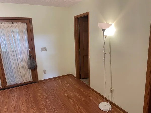 a view of a bathroom with wooden floor and mirror