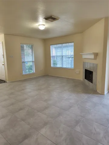 a view of an empty room with a fireplace and a window