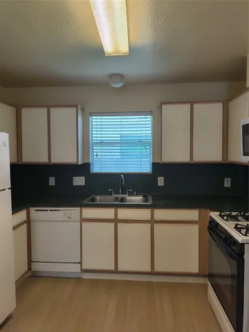 a kitchen with a sink a stove and cabinets