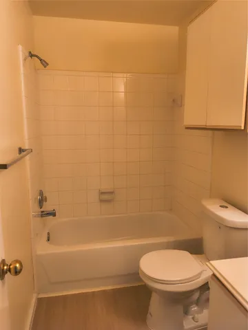 a white toilet sitting next to a bath tub and a shower